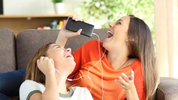 Chicas escuchan música en los auriculares