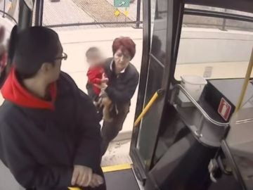 La conductora metiendo al pequeño en el autobús