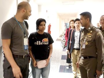 La joven saudí conversando con un jefe de la policía tailandesa La joven saudí conversando con un jefe de la policía tailandesa