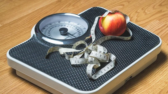 báscula con un metro y una manzana encima báscula con un metro y una manzana encima