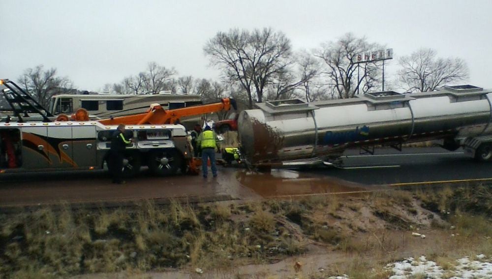 Un camión grúa intenta remolcar la cisterna de un camión.