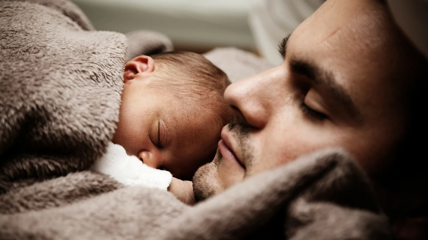 Un padre dormido junto a su bebé padre dormido con su bebé