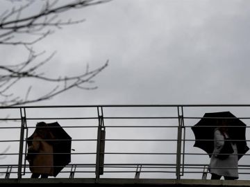 Imagen de archivo: varias personas se protegen del agua y del viento.