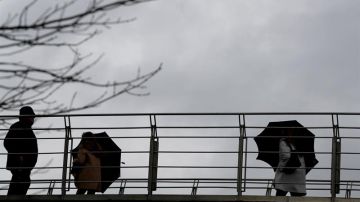 Imagen de archivo: varias personas se protegen del agua y del viento.