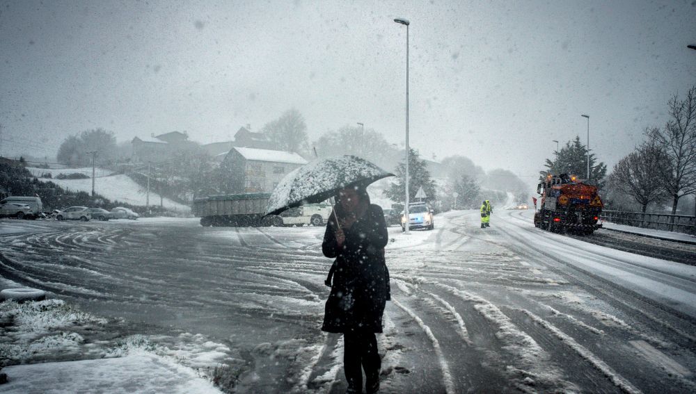 Una mujer se protege de la nevada este viernes en A Gudina (Ourense)