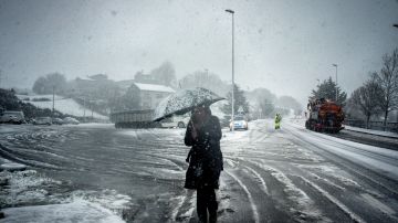Una mujer se protege de la nevada este viernes en A Gudina (Ourense)