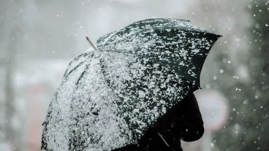 Una mujer camina por una calle nevada en A Gudiña Una mujer camina por una calle nevada en A Gudiña