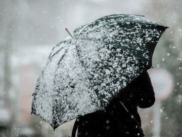 Una mujer camina por una calle nevada en A Gudiña Una mujer camina por una calle nevada en A Gudiña