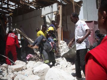 Un bombero somalí retira el cadáver de una víctima tras la explosión en Mogadiscio Un bombero somalí retira el cadáver de una víctima tras la explosión en Mogadiscio