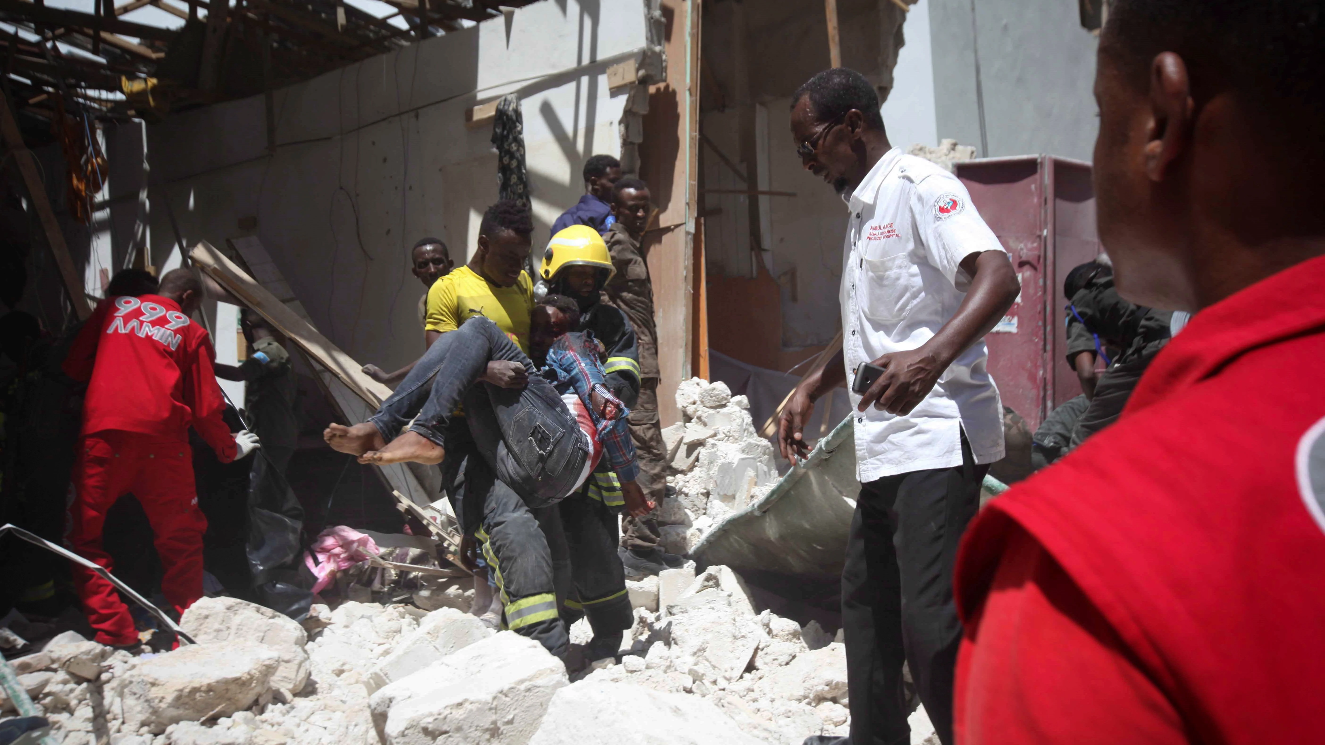 Un bombero somalí retira el cadáver de una víctima tras la explosión en Mogadiscio