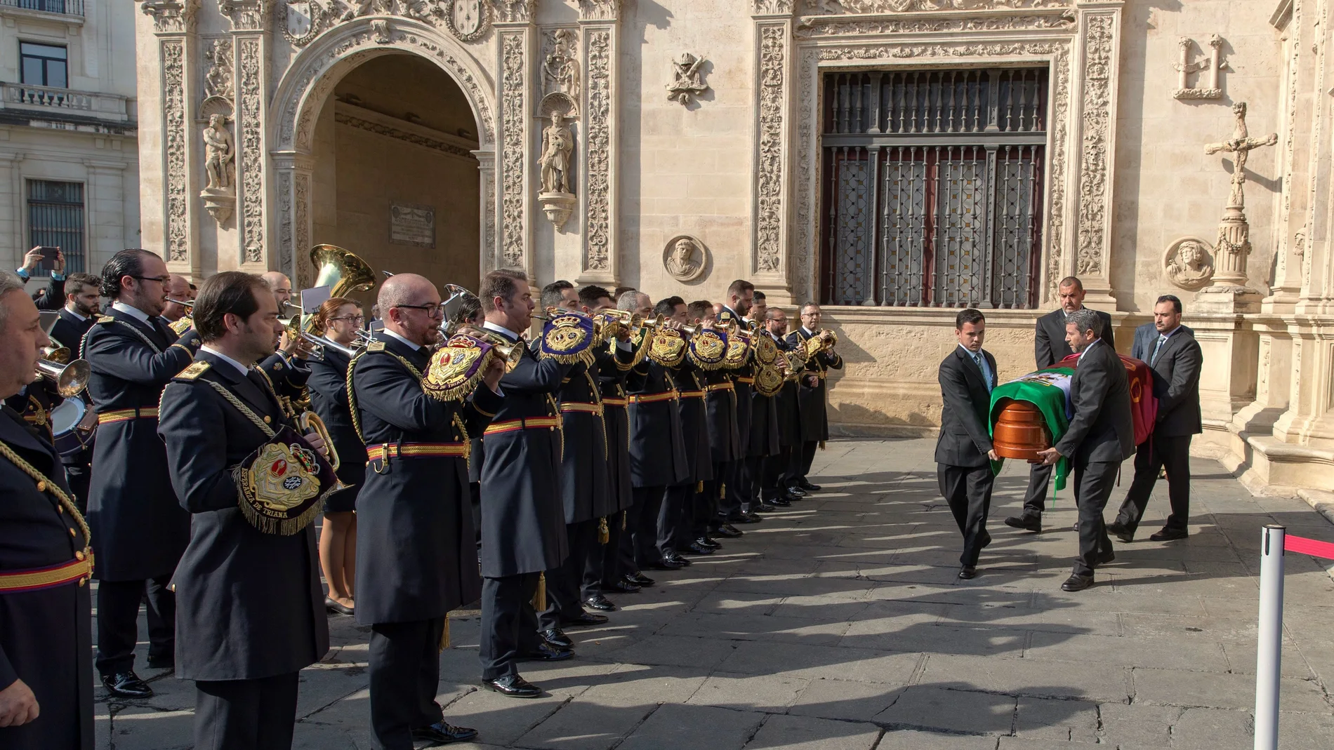 La banda de música de la Hermandad de las Tres Caídas tocando ante el Ayuntamiento de Sevilla para dar el último adiós al dramaturgo Salvador Távora