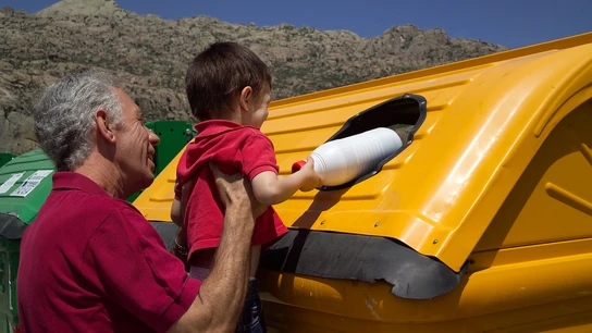 La primera fase del reciclaje, la separación en casa. Abuelo y nieto depositando envases