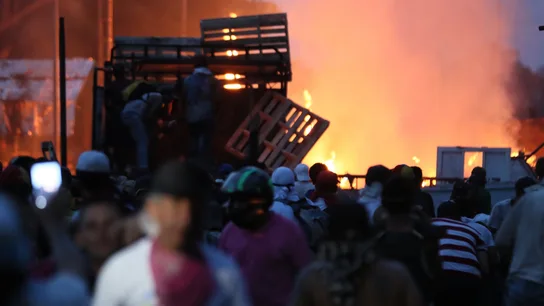 Manifestantes se enfrentan con miembros de la Policía Nacional Bolivariana, junto a un camión que transportaba ayuda humanitaria y fue quemado. Manifestantes se enfrentan con miembros de la Policía Nacional Bolivariana, junto a un camión que transportaba ayuda humanitaria y fue quemado.