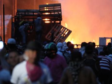 Manifestantes se enfrentan con miembros de la Policía Nacional Bolivariana, junto a un camión que transportaba ayuda humanitaria y fue quemado. Manifestantes se enfrentan con miembros de la Policía Nacional Bolivariana, junto a un camión que transportaba ayuda humanitaria y fue quemado.