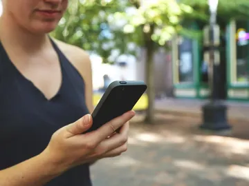 Una usuaria con su teléfono móvil Una usuaria con su teléfono móvil