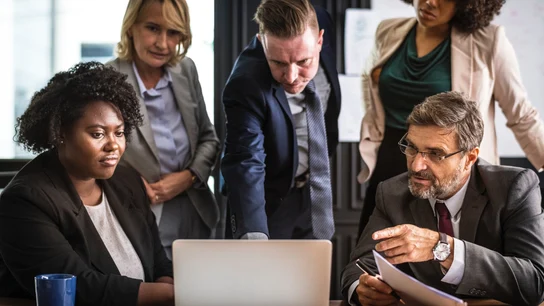 Hombres y mujeres en una reunión en una oficina Hombres y mujeres en una reunión en una oficina