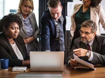 Hombres y mujeres en una reunión en una oficina Hombres y mujeres en una reunión en una oficina