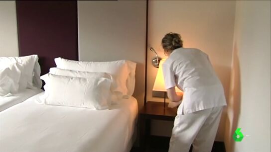 Una mujer limpia la habitaci&oacute;n de un hotel