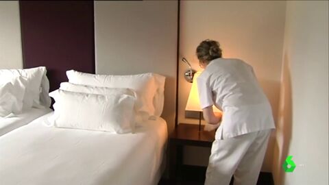 Una mujer limpia la habitaci&oacute;n de un hotel