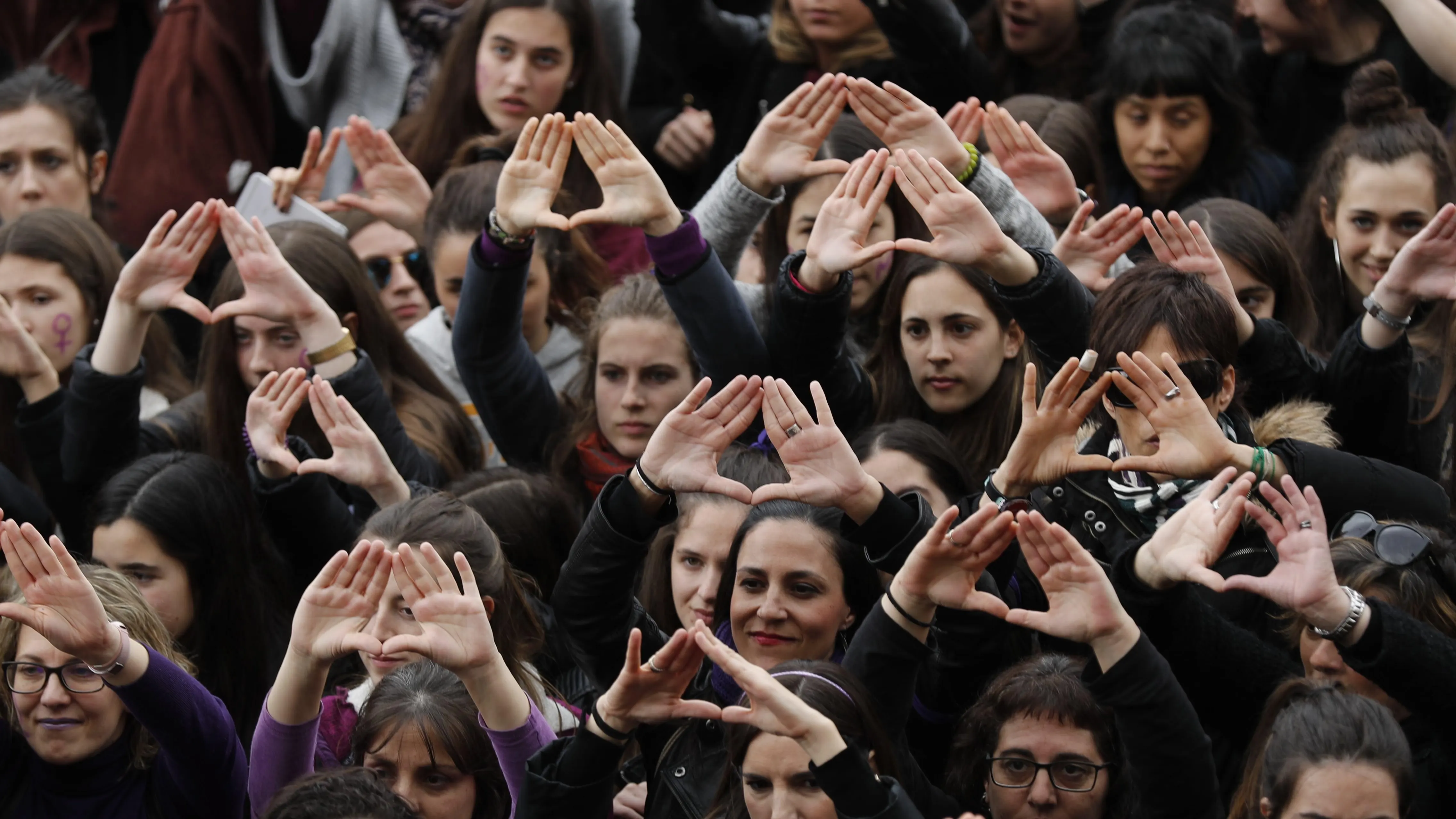 Manifestantes con el gesto del feminismo durante la manifestación