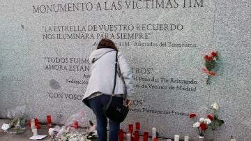 Flores y velas junto al monumento a las víctimas de los atentados del 11M