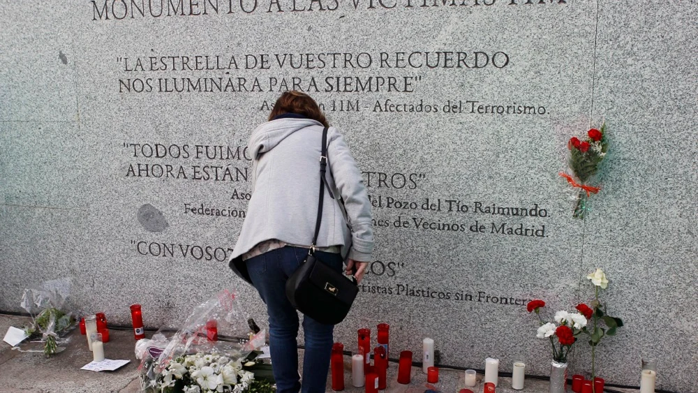 Flores y velas junto al monumento a las víctimas de los atentados del 11M