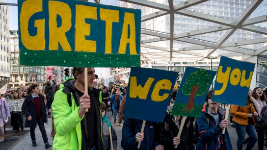 Participantes de una manifestación contra el cambio climático en Bruselas portan pancartas de apoyo a Greta Thunberg.