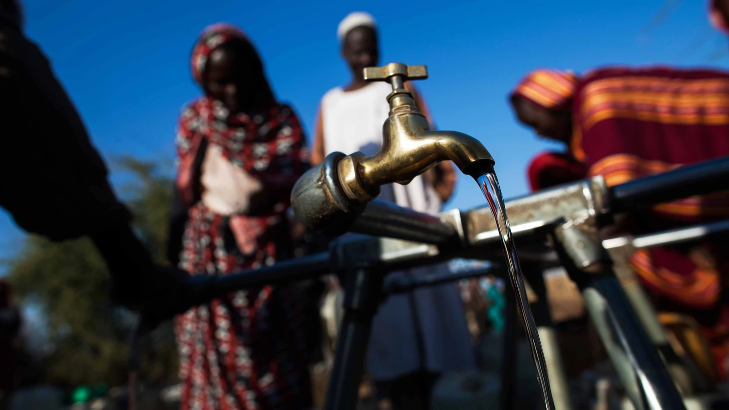 Refugiados recogen agua en un campo de Darfur, en Sudán. Personas recogen agua en un campo de refugiados en Darfur, Sudán, donde el acceso a este recurso es limitado.