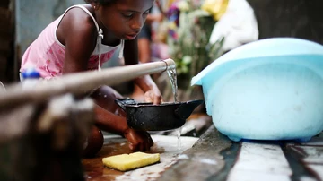 Una niña recoge agua en una favela en Río de Janeiro, Brasil.
