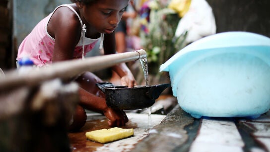 Una niña recoge agua en una favela en Río de Janeiro, Brasil.