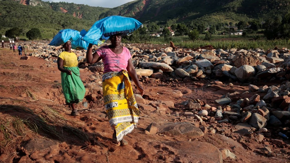 Dos mujeres portan sacos con ayuda humanitaria destinados a los afectados por el ciclón Idai