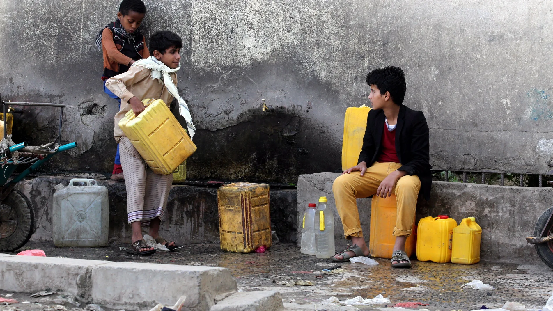Dos niños yemeníes recogen agua de una fuente en Saná, Yemen.