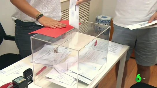 Una persona coloca un voto en el interior de una urna Una persona coloca un voto en el interior de una urna