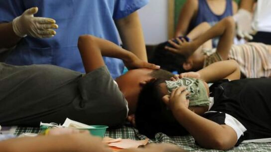 J&oacute;venes filipinos muestran dolor mientras les practican una circuncisi&oacute;n