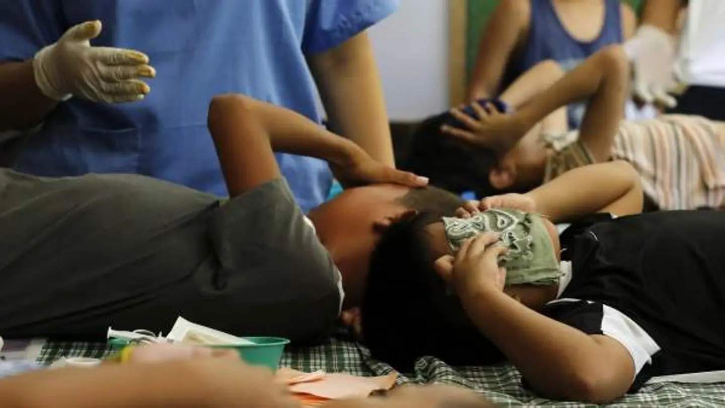 Jóvenes filipinos muestran dolor mientras les practican una circuncisión Jóvenes filipinos muestran dolor mientras les practican una circuncisión