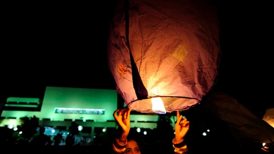 Celebración con motivo de la Hora del Planeta. Una joven sostiene un farolillo en una celebración con motivo de la Hora del Planeta.