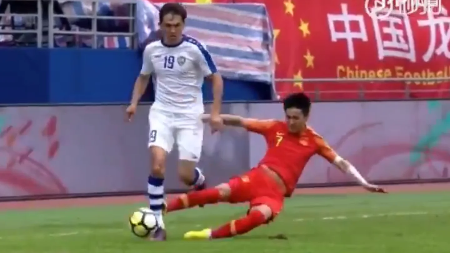 Wei Shihao realiza una dura entrada contra un rival Wei Shihao realiza una dura entrada contra un rival