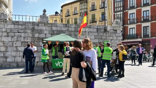Una pareja de lesbianas se besa frente a un puesto de Vox Una pareja de lesbianas se besa frente a un puesto de Vox