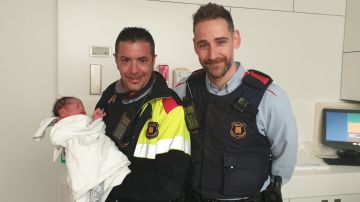 Los dos agentes de los Mossos d'Esquadra junto al recién nacido en el hospital.