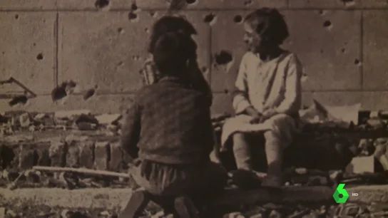 Niños sobre una pared con impactos de Metralla Niños sobre una pared con impactos de Metralla