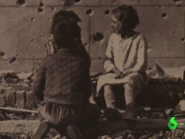 Niños sobre una pared con impactos de Metralla Niños sobre una pared con impactos de Metralla