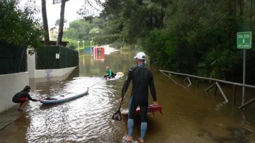Rescatan con tablas de paddle surf a unos vecinos atrapados por las inundaciones.