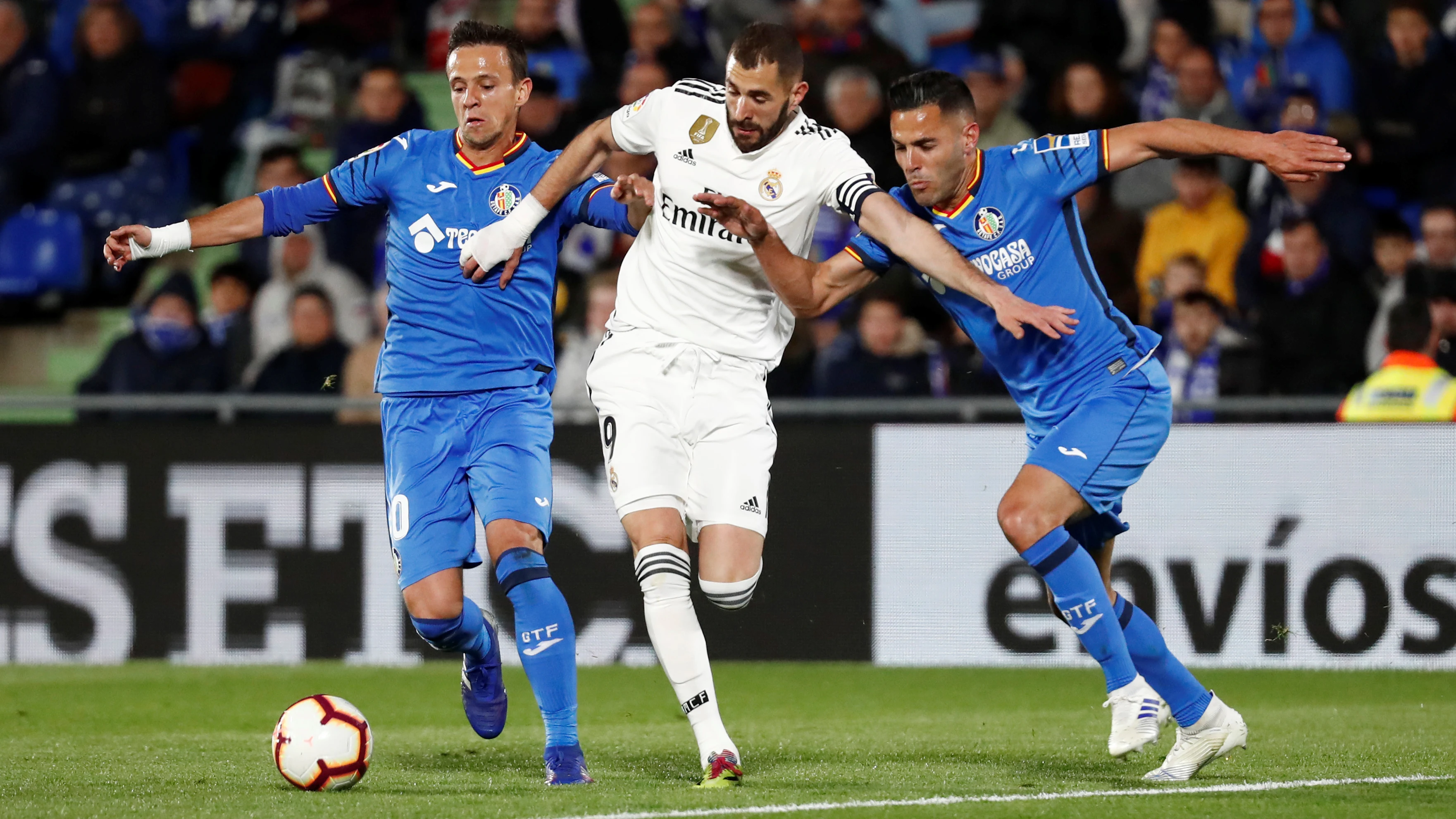 Benzema conduce el balón ante la defensa de los jugadores del Getafe