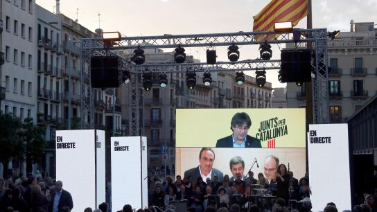 Carles Puigdemont desde Bruselas, y Josep Rull (i) Jordi S&aacute;nchez (c) y Jordi Rull (d), desde Soto del Real, intervienen en le acto de final de campa&ntilde;a de JxCat en Barcelona. 