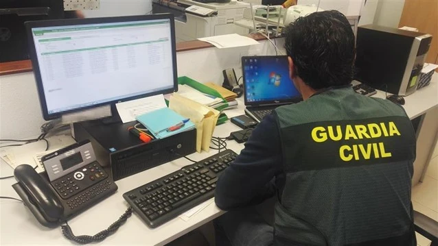 Imagen de archivo de un guardia civil consultando dos ordenadores