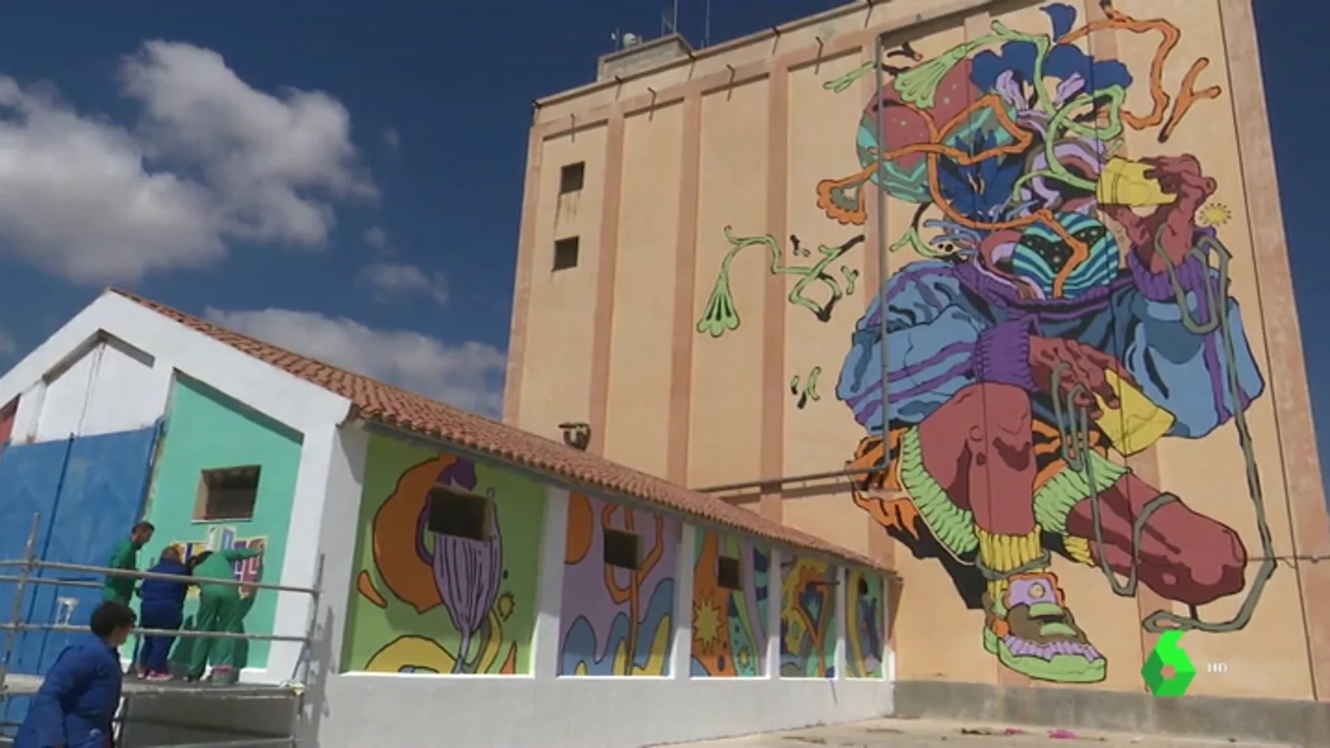 Imagen de silos de Ciudad Real pintados por artistas urbanos junto a jóvenes con discapacidad