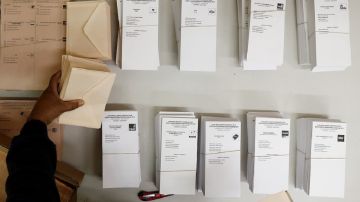 Una persona coloca en la mesa de un colegio electoral las papeletas con las diferentes opciones políticas