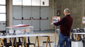 Un funcionario coloca la identificación de una mesa en un colegio electoral de Vitoria