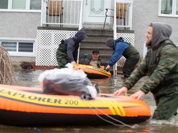 Personas siendo evacuadas en lancha tras las inundaciones en Quebec Personas siendo evacuadas en lancha tras las inundaciones en Quebec