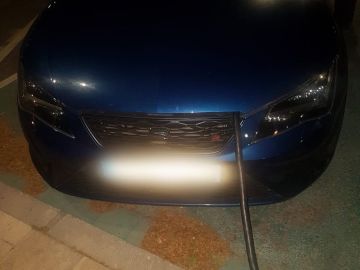 Un conductor simula cargar un coche eléctrico, aunque es gasolina Un conductor simula cargar un coche eléctrico, aunque es gasolina